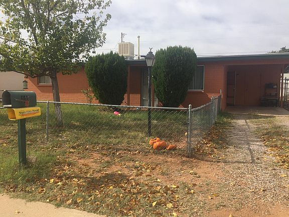 Fenced front yard with grass and trees