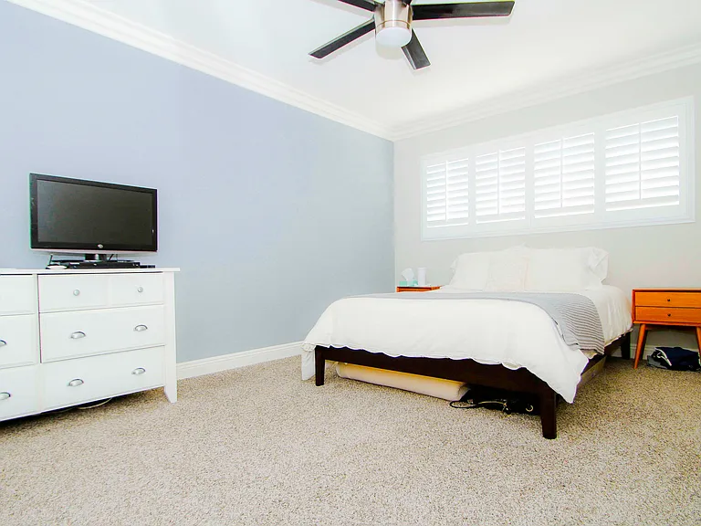 Naturally lit bedroom with ceiling fan.