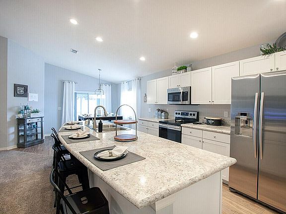 Open kitchen with Counter-height Island - New home for sale in Lake Alfred, FL. Photo showcases the