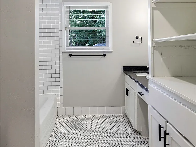 Bathroom with tile flooring, vanity, and shower combination