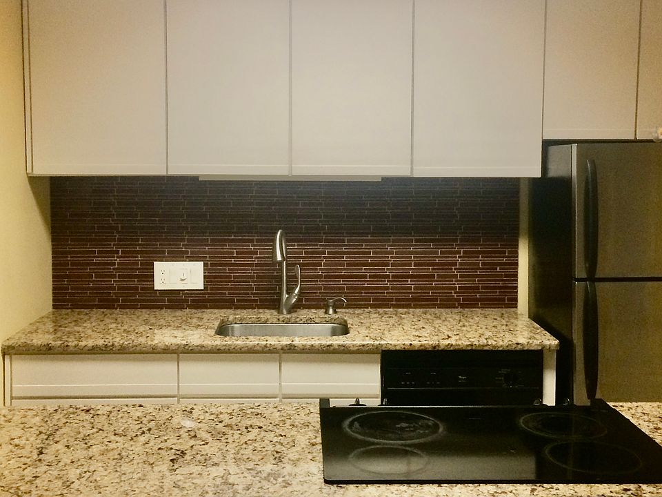 Kitchen with glass tile backsplash, granite countertops and lots of storage.