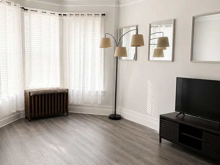 This is the living room that has all new flooring, new blinds and a lot of natural light. These three windows face the main entrance door.