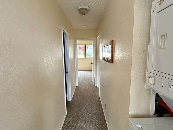 hallway leads to hall bath, bedroom at end, master bedroom and bath. You can see the washer dryer.