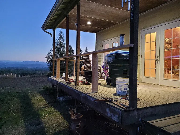 This side of the house faces Burnt Ridge and has two sets of french doors. The far set lead into the kitchen. The near set lead into a tiny dining/breakfast area or landing at the base of the stairs.