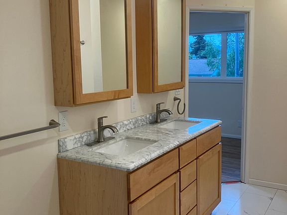 Large upstairs bathroom with maple cabinets and marble counters.