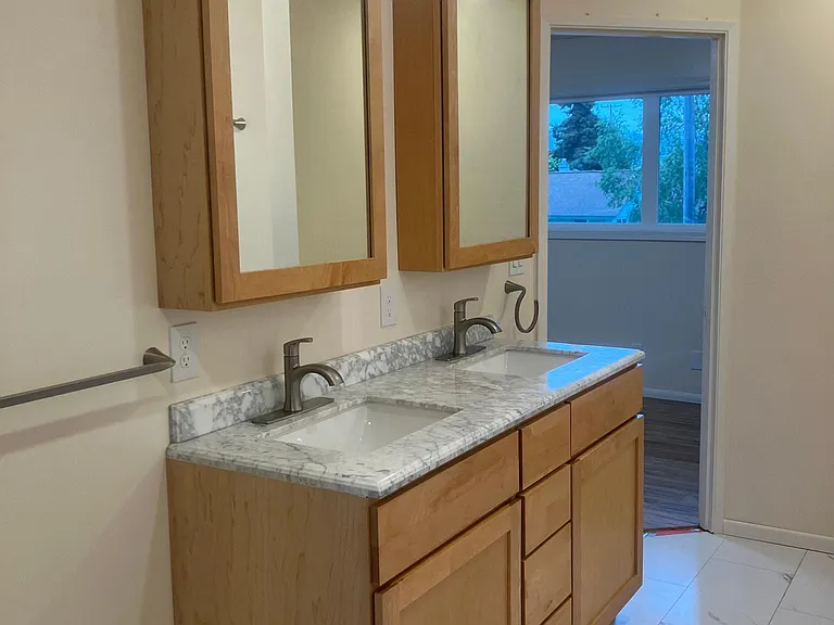 Large upstairs bathroom with maple cabinets and marble counters.