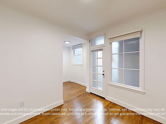 Bright, empty apartment entryway with hardwood floors, and large windows, featuring a door with glass panels.