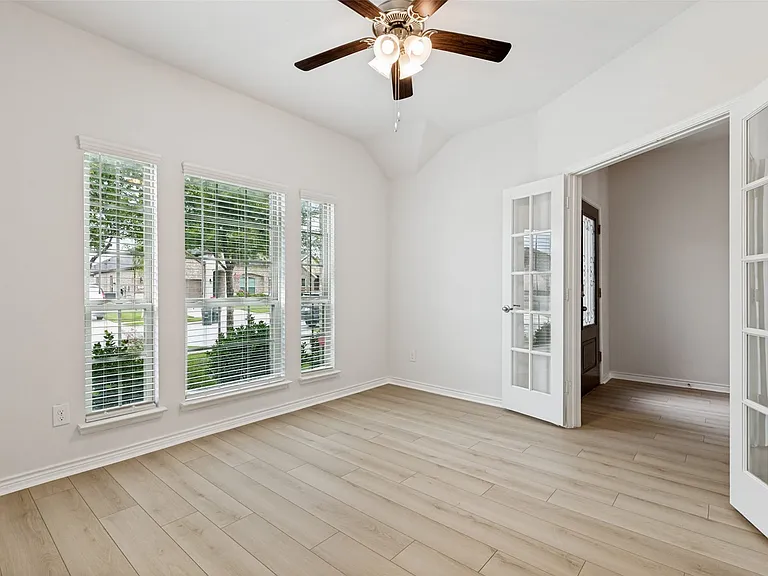 Room featuring a vaulted ceiling and light wood-finish flooring