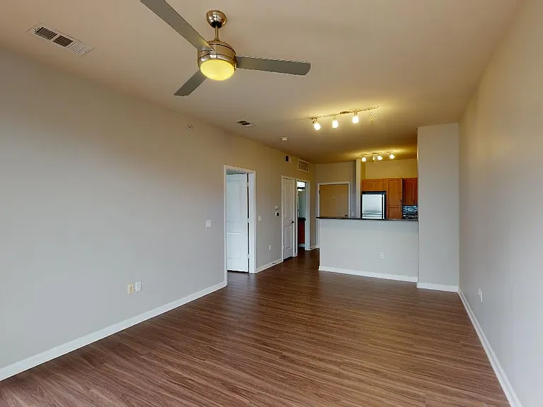 Apartment living room with wood-style flooring in select homes.