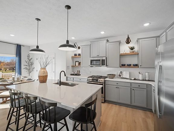 Kitchen with island, pendant lighting and open shelving