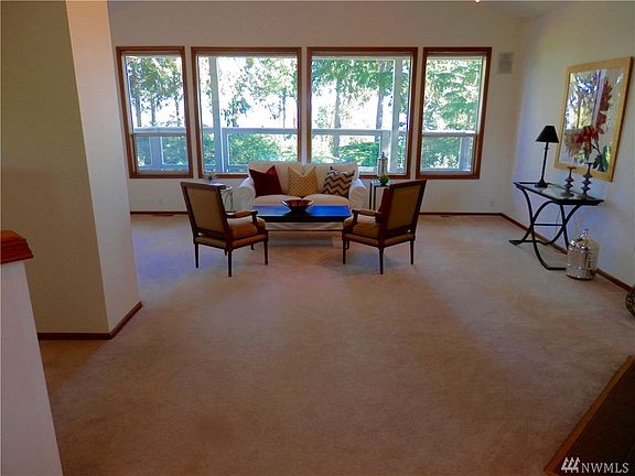 Large spacious living room with deck behind the windows. Lot's of light.
