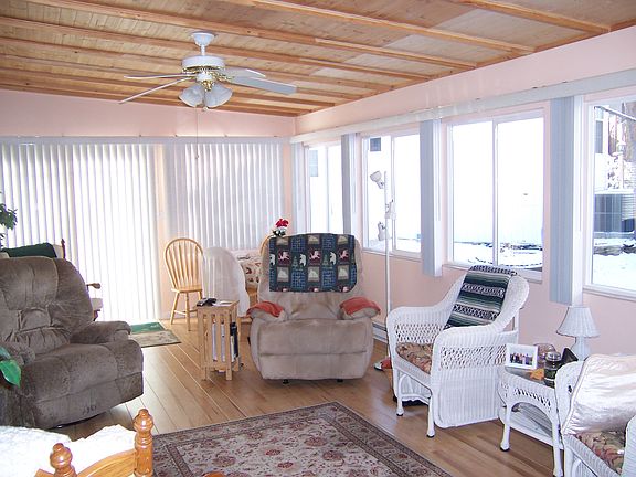 View of living room with lots windows. Knotty pine ceiling