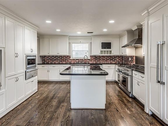 Over-the-top Chef's kitchen has custom cabinetry, 48" Thermador gas range, built-in Thermador fridge/freezer, 2 microwaves, 2 warming drawers, and Viking wine chiller. A Chef's and Entertainer's dream! Sure to impress!