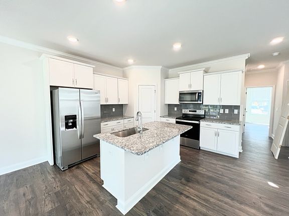 Stainless Steel appliances in kitchen; island has breakfast bar