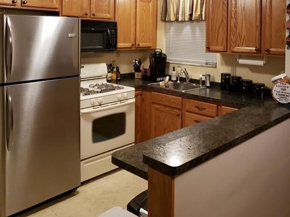 Plenty of cupboard space in this efficient kitchen.  Double tiered countertop pictured on right, with cabinetry below, as well. 