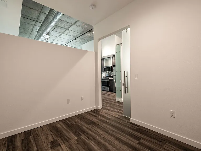 Bedroom with high ceiling open to work space in a Live and Work apartment at 1400 FIG Apartments in Los Angeles, California.