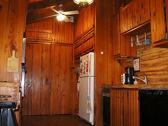 Kitchen with wood burning stove and overhead storage.