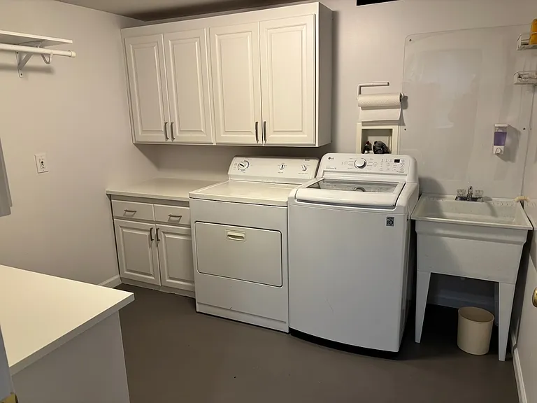 Full-size utility room with ample cabinets and mop sink.