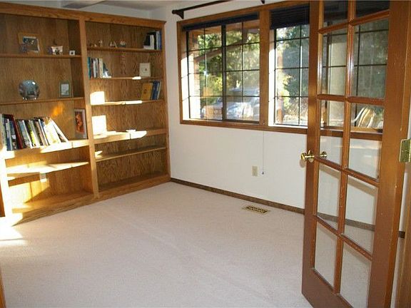 French doors lead to main floor den with woodwrapped windows and built in shelves.