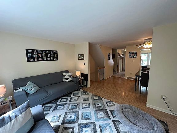 Living Room area looking baxk into the dining room. The Stairwell leads up to the third floor & down to the lower level laundry, 3rd bedroom & Storage areas.