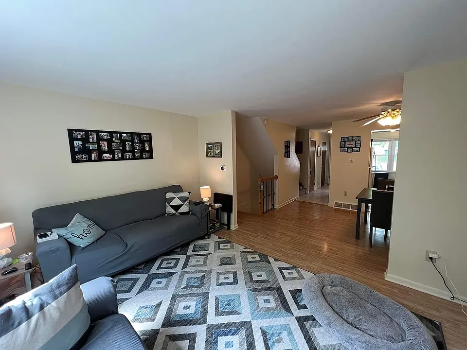 Living Room area looking baxk into the dining room. The Stairwell leads up to the third floor & down to the lower level laundry, 3rd bedroom & Storage areas.