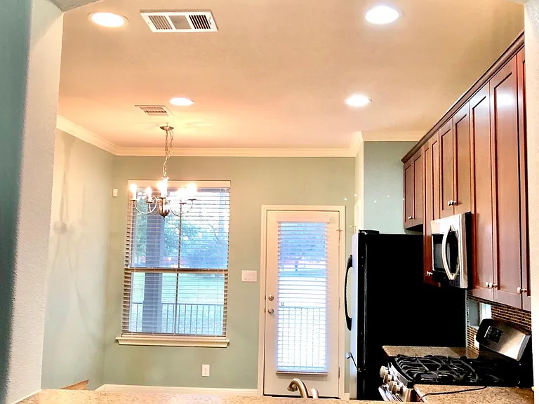 Kitchen opens to living area, recessed and upgraded lighting fixtures plus plenty of natural light with privacy being adjacent to green area