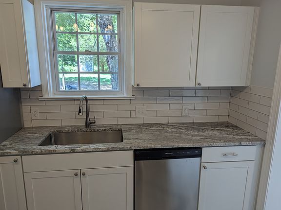 Kitchen with plenty of cabinet space, new dishwasher and sink plus granite countertops and a beautiful tile backsplash