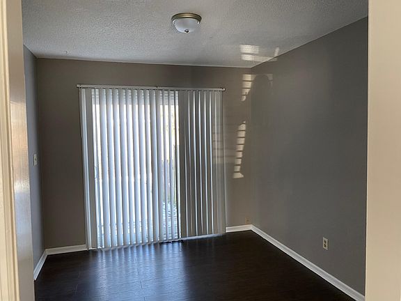 DR with vertical blinds looking into backyard