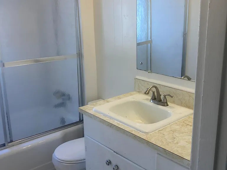 Bath with tub/shower, storage cabinet. In-wall storage also present, not shown.