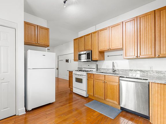 The kitchen includes a gas range, a microwave, a standing refrigerator/freezer, a dishwasher, and a garbage disposal.