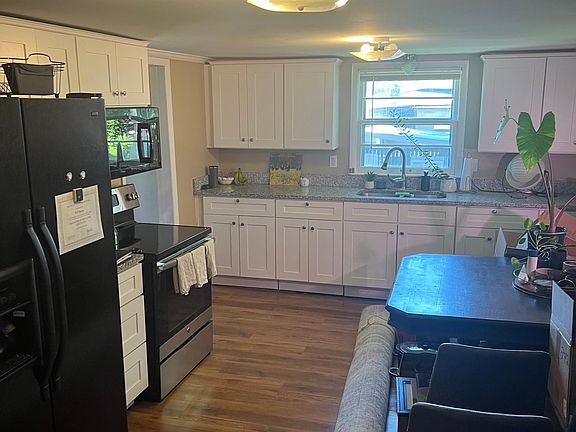 Very large eat-in kitchen with white shaker cabinets and granite