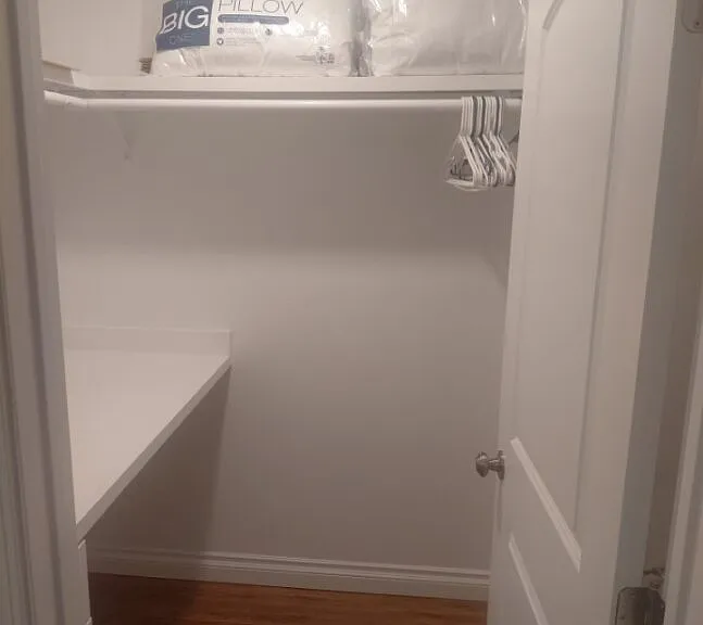 Spacious Walk-in Closet in bedroom with laminate flooring and desk table.