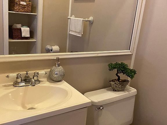 Half bath off of front bedroom with built ins for storage and books ,new sink cabinet and toilet.