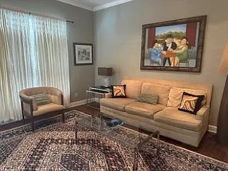 Living room has a large window and exterior door to the pool patio.