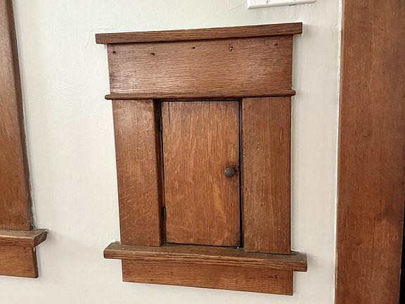 Original details include this charming door through which mail is deposited. Even this tiny detail was lovingly designed and created over 100 years ago by the craftsmen who built this gem!