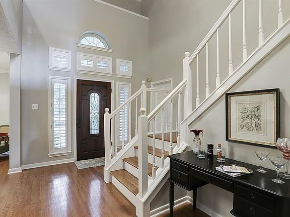 As you enter to the open high ceilings you see the beautiful solid wood door with leaded glass and halfmoon transom window, hardwood floors, and plantation shutters.