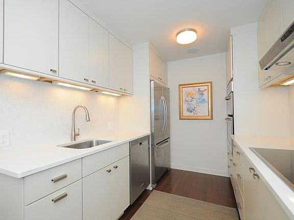 The kitchen is done in a sleek Euro style with gorgeous cabinetry and KitchenAid appliances.