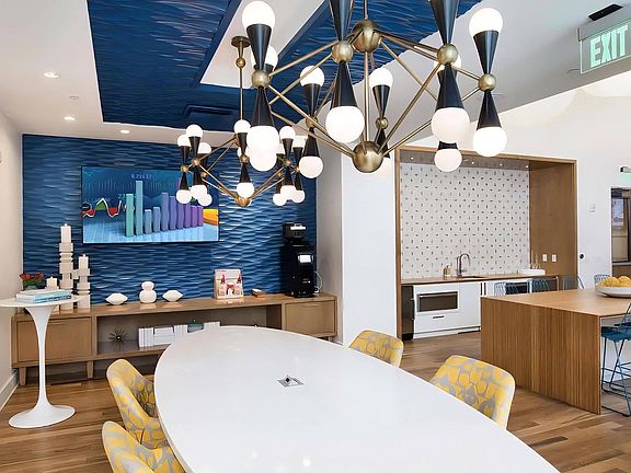 Community Lounge with TV, Coffee Station, and Modern Lighting Fixtures