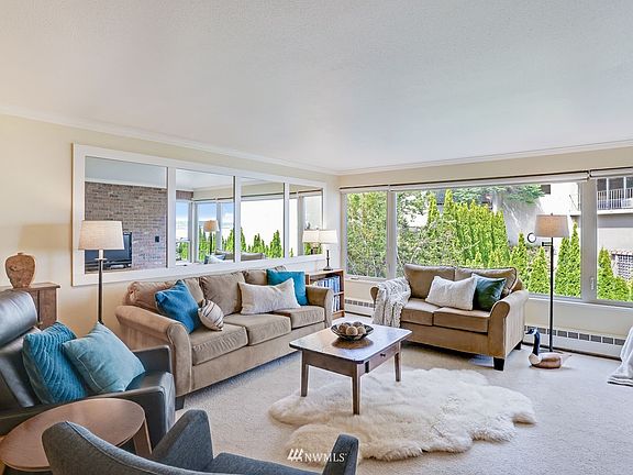 The living room is virtually a wall of updated windows. It features updated carpet and carpet pad as well the crown molding that wraps the ceiling! The wall of mirrors brings the outdoors inside, connecting both spaces in this wonderful sanctuary!