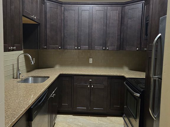 Fully equipped kitchen, with multiple cabinets, a dishwasher, stove, and fridge.