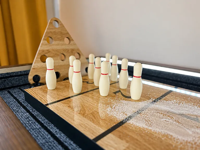 The Five Point Loft game room is ready for the challenge! This entertaining space boasts a large smart tv, plenty of games, shuffleboard, plush bean bags and seating, and playful lounge energy upstairs.