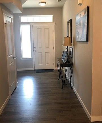Spacious, inviting entry way with coat closet. Large wall could accommodate bookshelves, or additional storage. Space under stairs for storage.