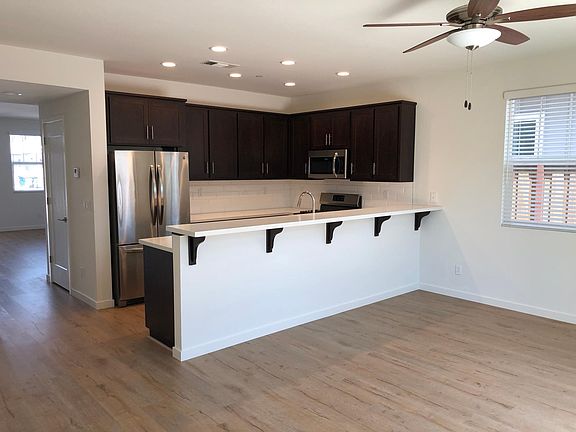 Kitchen includes refrigerator, range, microwave/hood, D/W, and bar seating