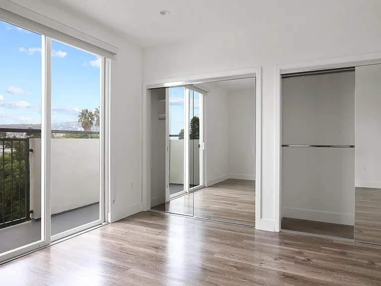 Bedroom with Double Mirrored Closet, Vinyl Flooring, and Balcony