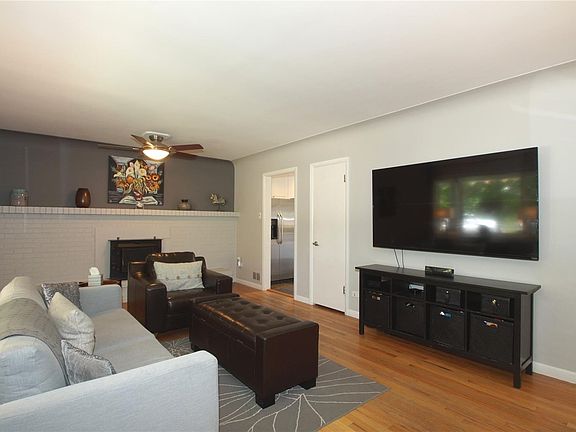 A spacious fireplace mantle, ceiling fan and coat closet round out the living room space.