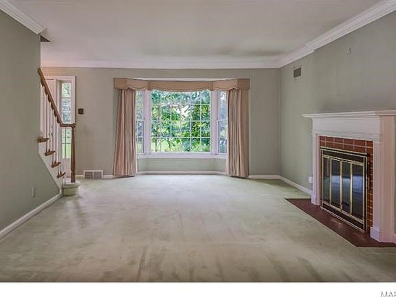 View from the dining area into the living room. That is a wood-burning fireplace!