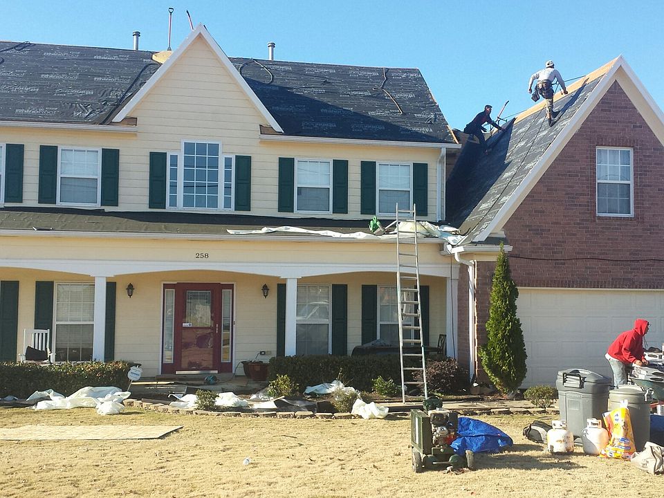 Front of home with roofers