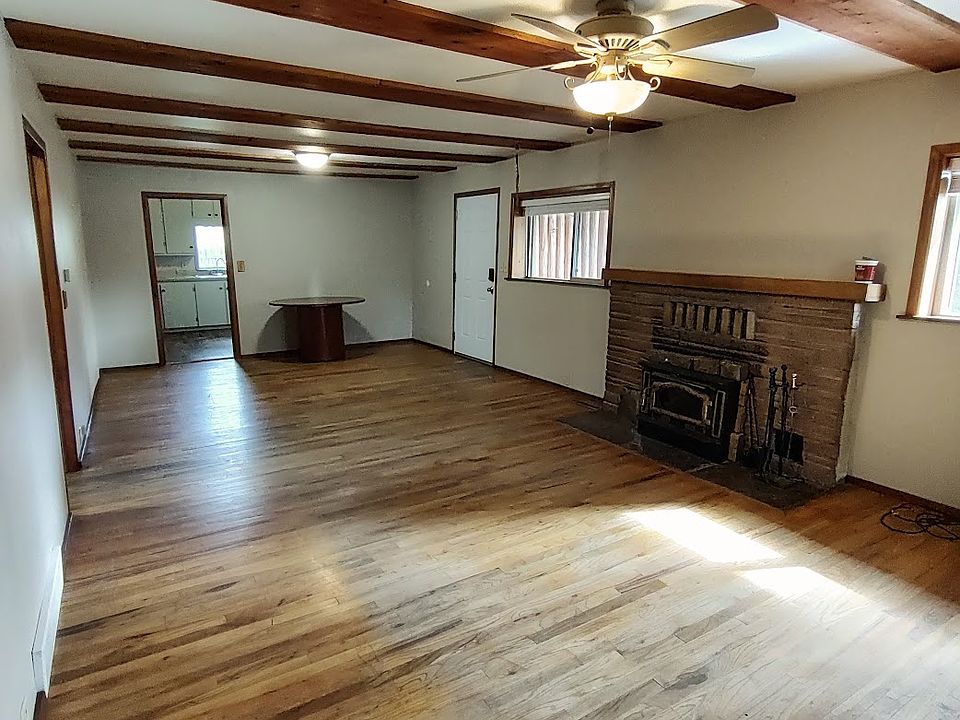 Front door enters the living room, wood burning fireplace