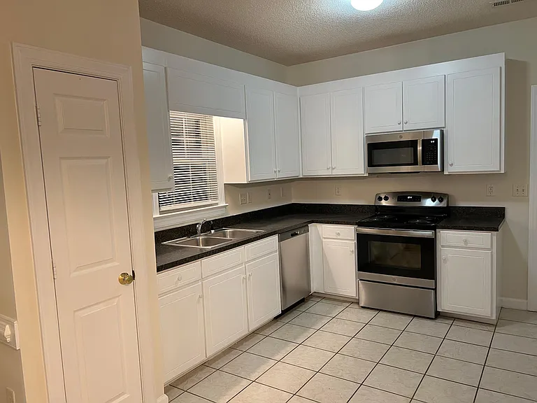 Kitchen with new stainless steel stove, microwave and dishwasher