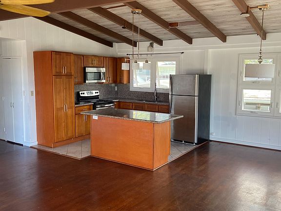 Kitchen:
Open kitchen with granite countertops, wood cabinetry, and stainless-steel appliances.